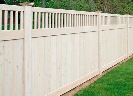 A white fence with a wooden top and bottom.